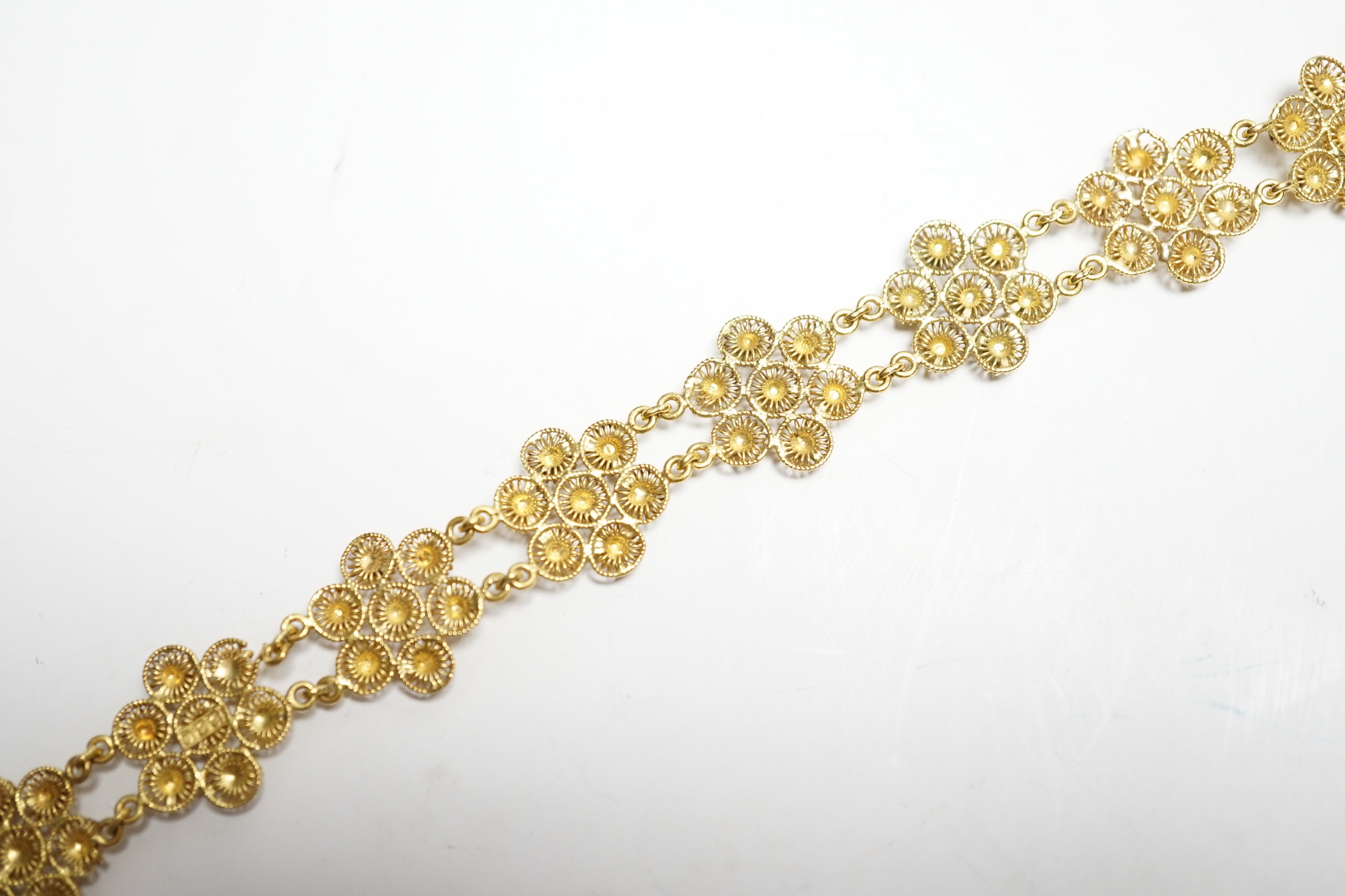 A yellow metal 'bright cut engraved' flower head link bracelet, 16cm, 14.7 grams.